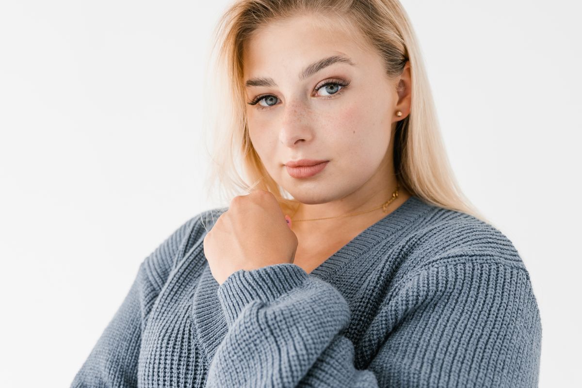 A cashmere sweater laid flat with a sweater comb beside it
