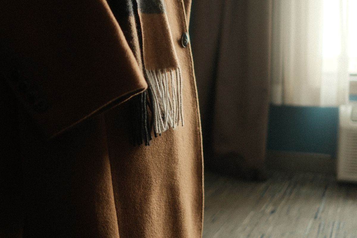 Folded wool coat fabric swatches in navy and camel tones