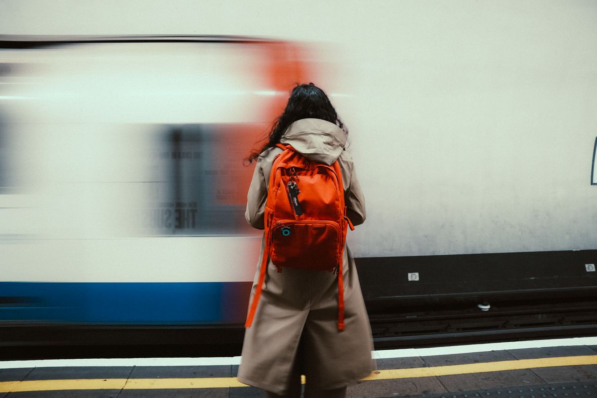 A commuter backpack on a train platform railing