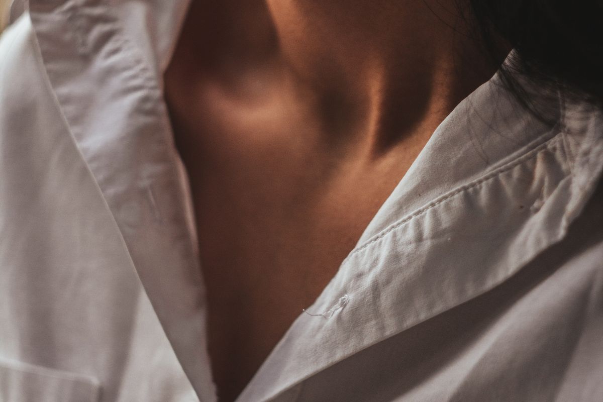 Crisp white cotton dress shirt on a wooden hanger